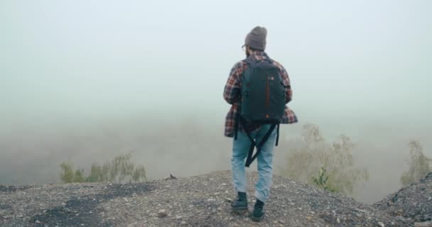 Matkustaa vuorilla. Nuori mies tyylikäs parta oppii vanhan kartan kävely vuorella peitetty paksu sumu — kuvapankkivideo