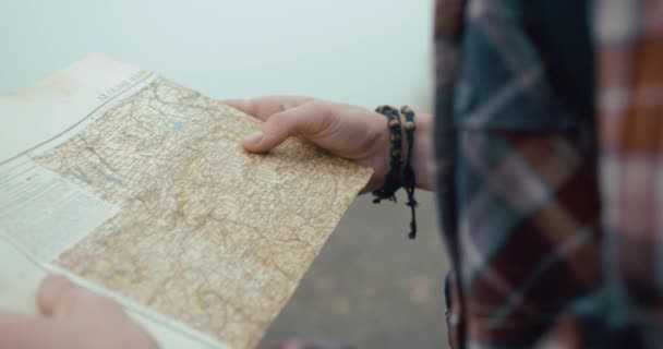 Viajando por las montañas. Viejo mapa en manos de los hombres mientras está en el bosque cubierto de espesa niebla — Vídeo de stock