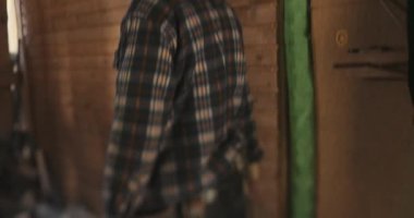 Elinde balta tutan ve ağır çekimde odun kesen bir oduncu..