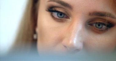 İş kadınının yakın çekim görüntüsü yorgun gözler. Gözlüklerini çıkarıyor ve dizüstü bilgisayar üzerinde çalışıyor.