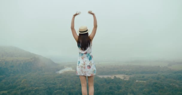 Charming Young Woman Summer Hat Dress Stretches Standing Top Mountain – stockvideo