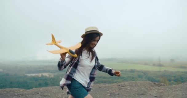 Happy Young Girl Hat Plays Little Yellow Airplane Running Rock – Stock-video