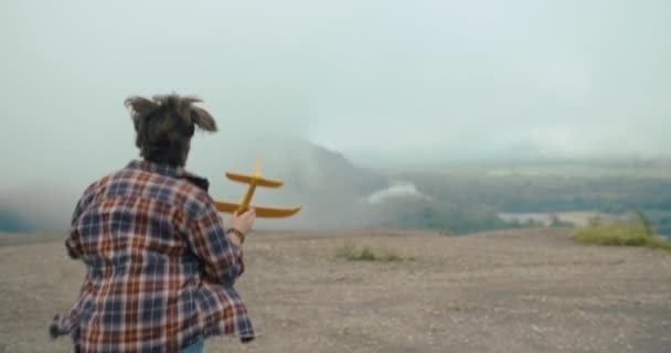 Spójrz Tyłu Młodego Człowieka Koszuli Biegającego Skale Żółtym Samolotem Ręku — Wideo stockowe
