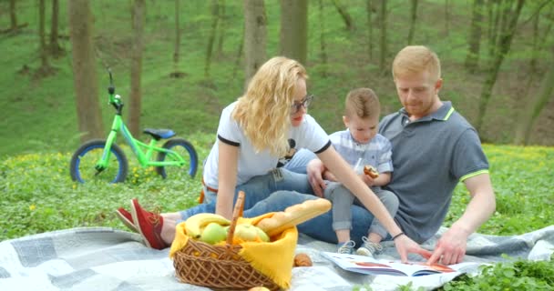 Beautiful Happy Portrait Family Reading Book Picnic Green Forest Footage — Vídeos de Stock