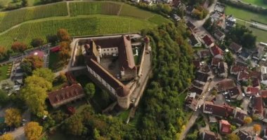 Aerial copter flight over beautiful sunny city Weinsberg, Heilbronn district in Germany. View of the famous blooming vineyard