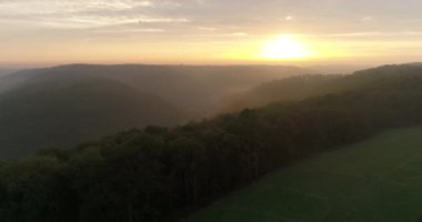 Flying copter over charming landmark of Heilbronn in Germany. Beautiful view of the foggy mountains covered with green thick forests during the sunset