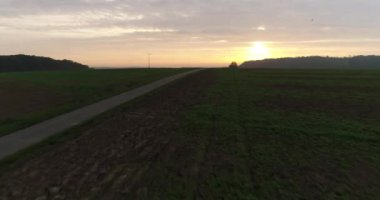Flying copter over greeny fields in little town Wiensberg in Heilbronn district, Germany during the sunset