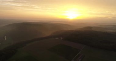 Aerial flight of copter over beautyful foggy fields and mountains during the bright sunset in Heilbronn, Germany. 4k footage