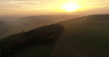 Aerial copter flight over the charming misty fields, mountains and forests during the sunset in Heilbronn, Germany. 4k footage