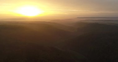 Flying copter over beautiful mountains covered with forests and thick fog during the sunset in charming Heilbronn, Germany. 4k footage