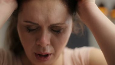 Portrait of the sad depressed curvy woman crying and wiping her tears with the dumbbell