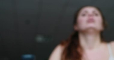 Blurred obese womanworks out on the elliptical trainer. The sport equipment handle in the focus