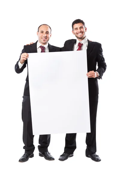 Двое бизнесменов улыбаются и держат рекламный щит — стоковое фото