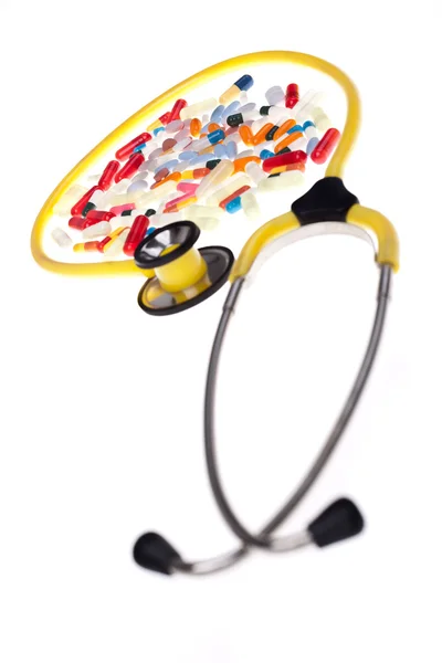 Pigułki i żółty stetoskop — Zdjęcie stockowe