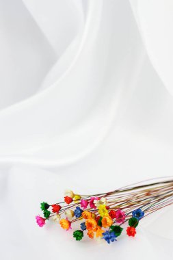 Beyaz ipek arkaplandaki küçük doğal kuru çiçekler, kopyalama alanı 