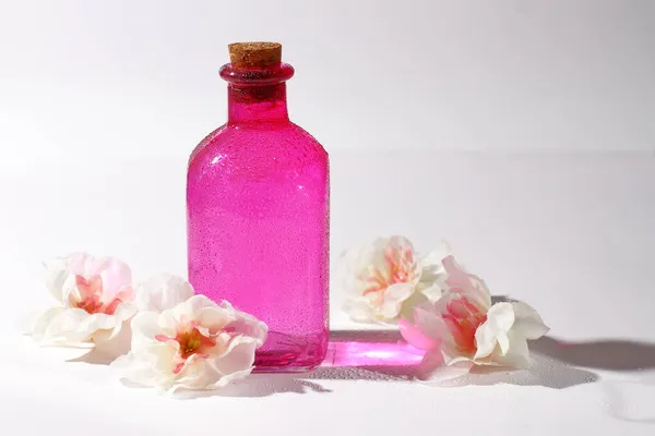 Roze Glazen Fles Met Bloemen Cosmetische Container Met Reflectie — Stockfoto