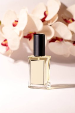 Glass perfume bottle with orchid, moke up