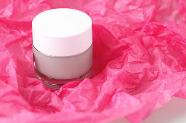 Açık yeşil krem, cam kavanozda losyon pembe kağıt üzerinde bckground