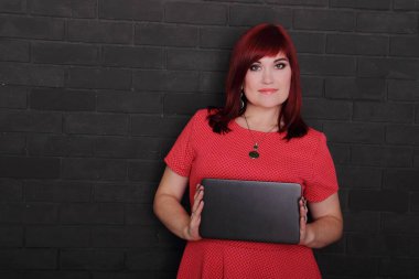 Genç kızıl saçlı kadın boş tahtayı gösteriyor.