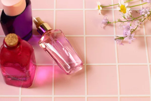 Parfümflasche Auf Rosa Tisch Mit Blumen — Stockfoto