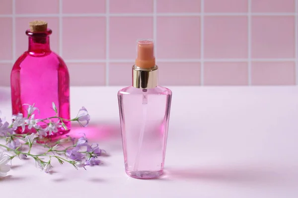 Botella Perfume Sobre Mesa Rosa Con Flores —  Fotos de Stock