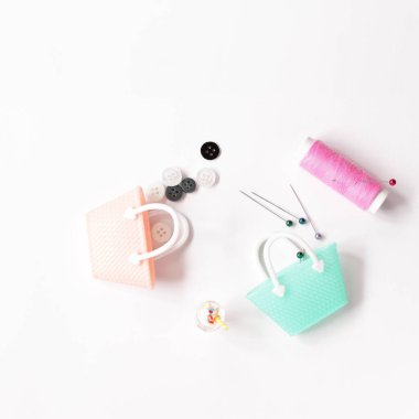 Oyuncak poşetlerle dizilmiş pembe iplik ve iğneler