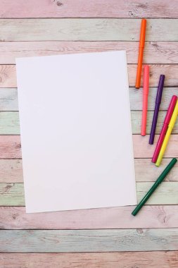 A4 blank white paper and florister different colors on wooden table