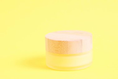 Sarı üzerine bambu musluğu konmuş Galss kozmetik şişesi.