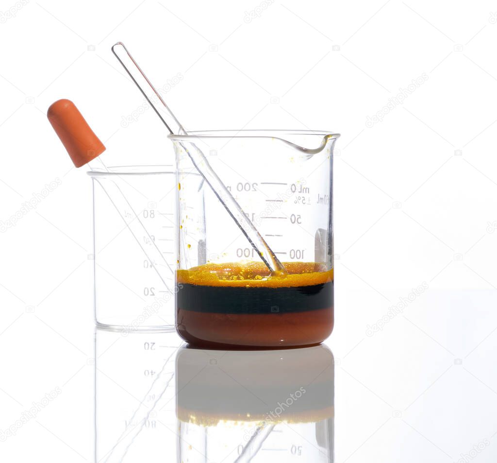 Closeup chemical ingredient on white laboratory table. Ferric Chloride Liquid with stirring rod in Beaker. Side View