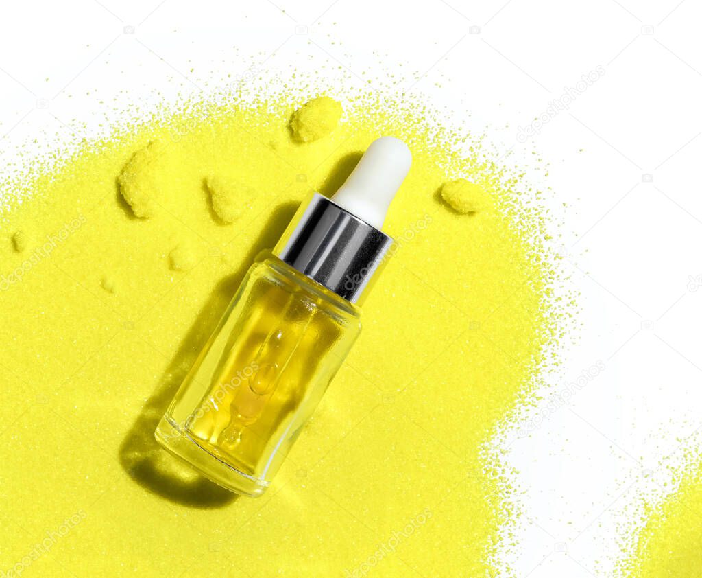 Yellow cosmetic liquid (oil) in  Dropper Bottle place on Potassium Chromate powder.