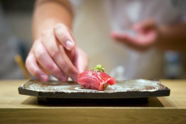 Seramik tabakta servis edilen taze wasabi ile ton balığı suşisi. Japon suşi restoranında Omakase deneyiminin tadını çıkarın..