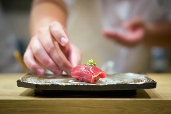 Seramik tabakta servis edilen taze wasabi ile ton balığı suşisi. Japon suşi restoranında Omakase deneyiminin tadını çıkarın..