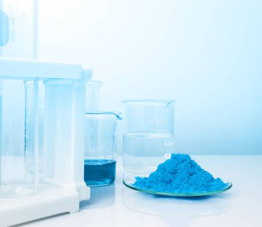 Beyaz laboratuvar masasında yakın çekim inorganik kimyasal. Bakır (II) sülfat, alkol. Kozmetik ve Tuvalet ürünleri için kimyasal malzeme.