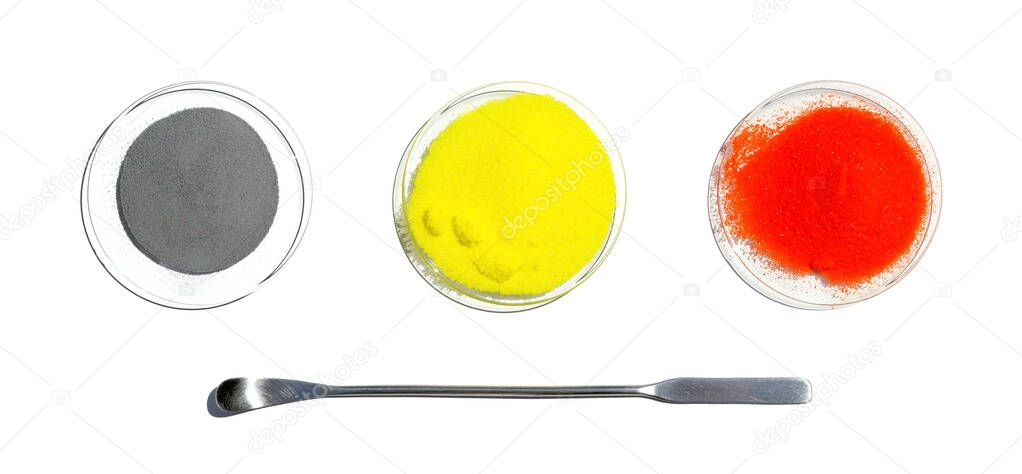 Zinc Powder, Potassium Chromate and Potassium Dichromate in chemical watch glass placed next to the stainless spatula. Closeup chemical ingredient on white laboratory table. Top View