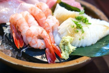 Sashimi seti ahşap bir tabakta güzelce düzenlenmiş. Japon Mutfak Büfesi. Şefin Seçimi: karides, wawa, ton balığı ve hamachi.