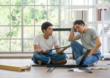 Ev yenileme servisi. İki marangoz toplanan bankın tipini tartıştı. Sabah çalışma atmosferi oturma odasında. Tamirci yeni eve ahşap bank kuruyor..