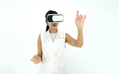 Sanal gerçeklik gözlüğü takan beyaz elbiseli Asyalı kadın interaktif bir oyun oynuyor. Gelecek Teknolojisi Konsepti.