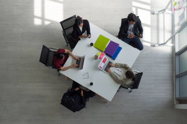 Modern ofiste aynı masada çalışan işletme yöneticileri. Laptop, tablet, cep telefonu ve kahve. Kurumsal iş adamları konsepti. Üst Görünüm