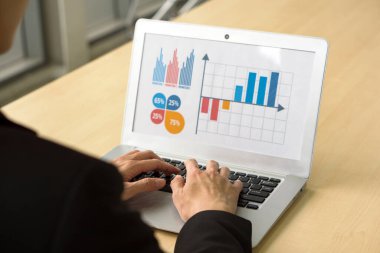 Takım elbiseli işadamlarının arka görünümü ofiste oturup dizüstü bilgisayarda siyah ekranla klavye yazarak grafikler ve çok renkli grafiklerle sunum yapmaları.