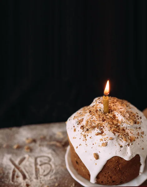 Sobremesa de Páscoa decorada com vela branca em uma tábua de madeira. — Fotografia de Stock