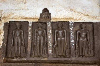 Carved idols of Digambar Jain Tirthankaras on the rock of Mangi Tungi, Nashik, Maharashtra, India. clipart