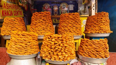 Tatlı tezgah Khaja 'ya Odisha, Puri, Odisha, Hindistan' ın meşhur tatlı yemeğini satıyor. Haja katmanlı bir hamurdur. Kızarmış ve şeker tarifine batırılmış.