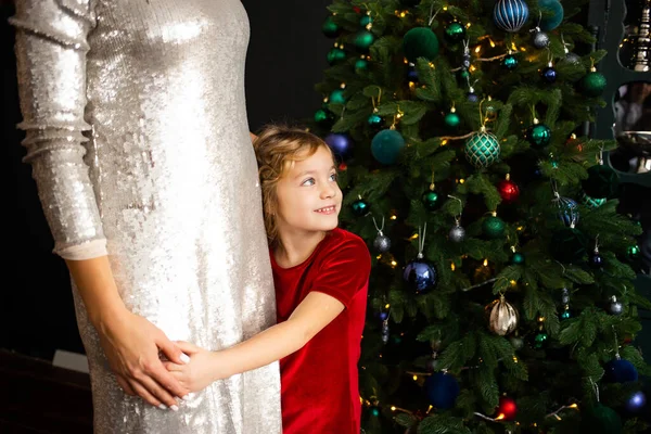 クリスマスツリーの近くで母親を抱きしめる少女 メリークリスマスとハッピーホリデー — ストック写真