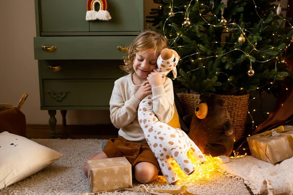 Menina Sentada Chão Casa Natal Abraçando Sua Girafa Brinquedo Bonito — Fotografia de Stock