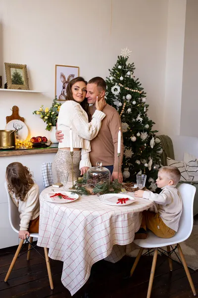 家庭でクリスマスを待っているキッチンで家族 陽気な両親と彼らのかわいい子供たちは自宅でクリスマスを待っています — ストック写真