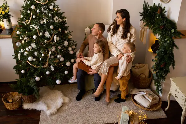 部屋にプレゼントを持った家族を愛する メリークリスマスとハッピーホリデー 親とその小さな子供たちは屋内で楽しんでいます — ストック写真