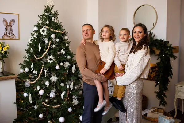 部屋にプレゼントを持って幸せな家族 メリークリスマスとハッピーホリデー 親とその小さな子供たちは屋内で楽しんでいます — ストック写真