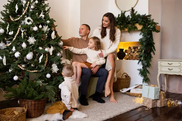 親や子供たちは 屋内で楽しんでいました メリークリスマスとハッピーホリデー 自宅でプレゼントを持つ家族を愛する — ストック写真