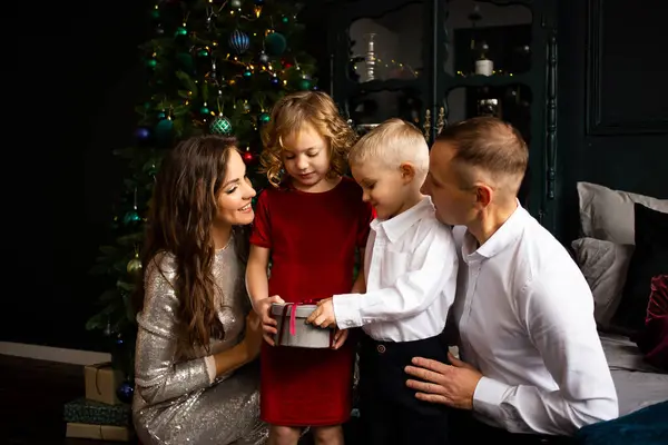 両親と可愛い娘と息子が贈り物を交換する メリークリスマスとハッピーホリデー — ストック写真