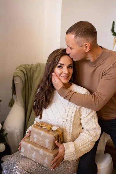 Happy charming woman dressed in knitwear talking to her handsome boyfriend spending time at cozy home